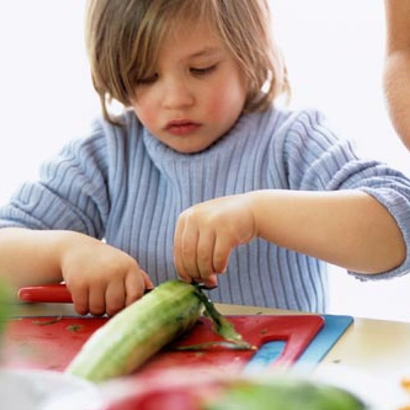 Boy cutting cucumber