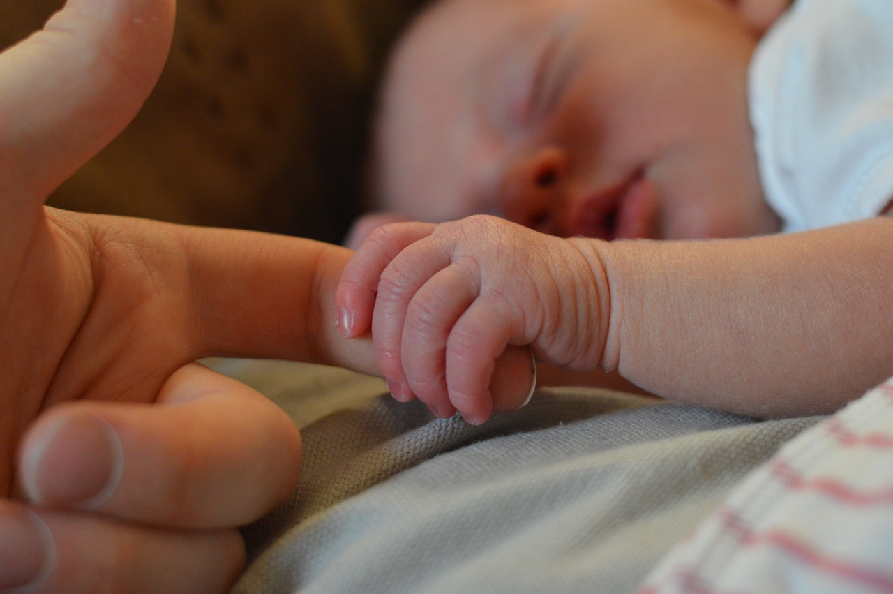 infant sleeping holding parent