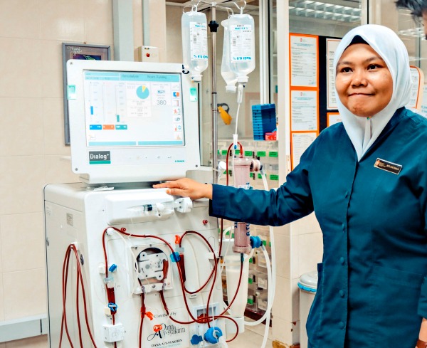 Nurse Siti Fatimah explains the functions of the haemodialysis machine. Haemodialysis can replace part, but not all, of the kidney’s functions. The machine filters the blood of waste materials, salt and excess fluid before returning the cleaned blood to the body. Patients have to ensure they limit their intake of liquid through drink and food to stop build-up of fluid in the body in between treatments. They also have to control their diet. 