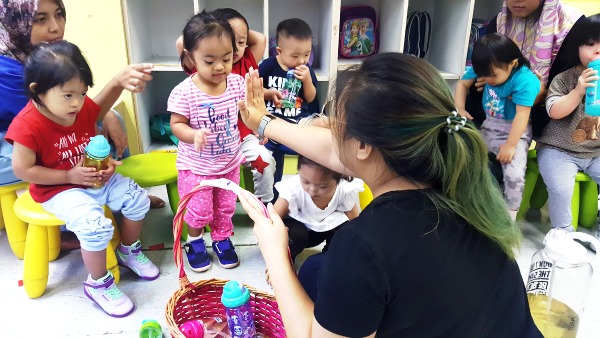 Soraya interacting with her teacher at the Toddler Class in KDSF.