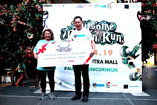 Feilina Feisol, NASOM chairman receiving RM20,000 from HC Chan, Sunway Malls and Theme Parks CEO. The money was chanelled from the run for NASOM.