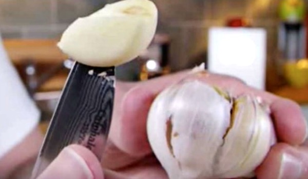 Knife pulls out garlic bulb. Food Hacks: 5 Secrets to Peeling Garlic
