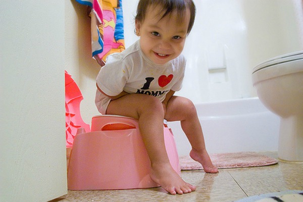 Smiling girl on potty. Toilet Training your Toddler Fast, using the Malaysian Way