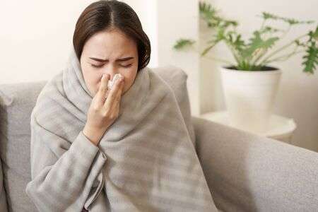 Asian Cute of girl having flu season and sneeze using paper..