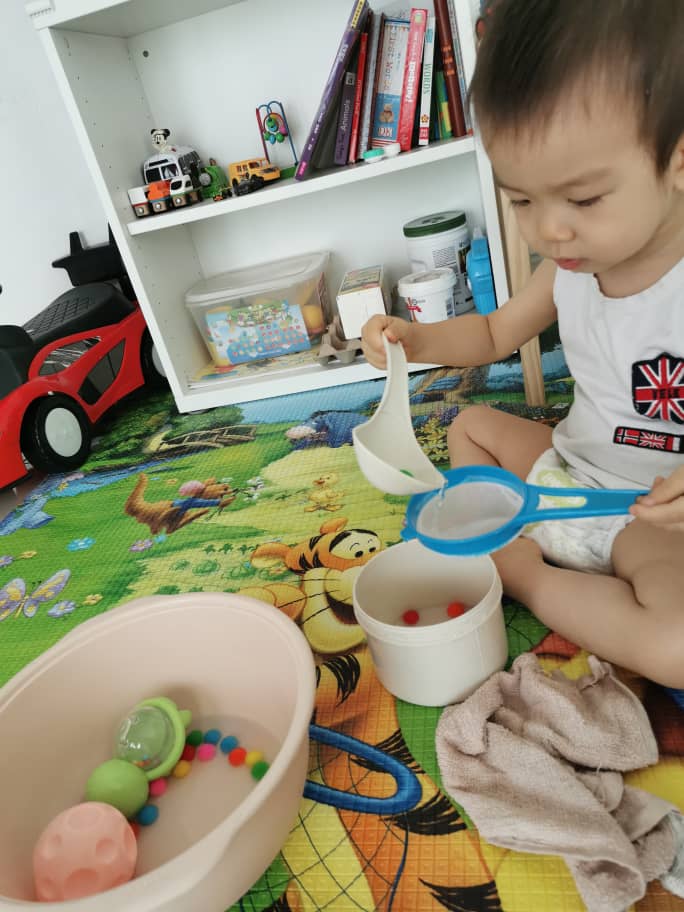 Kid play with safe cooking utensils during his playtime. 