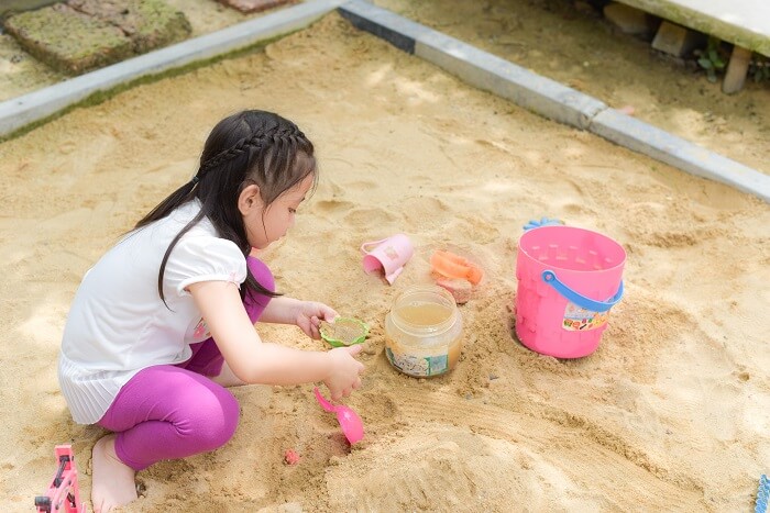 a girl is having fun playing with sand