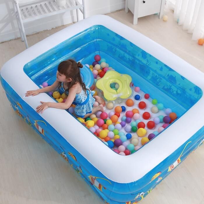 a girl is having fun in inflatable pool at home
