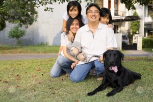 Family in Park With Black Labrador