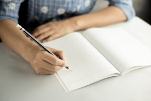 Woman Writing in Book
