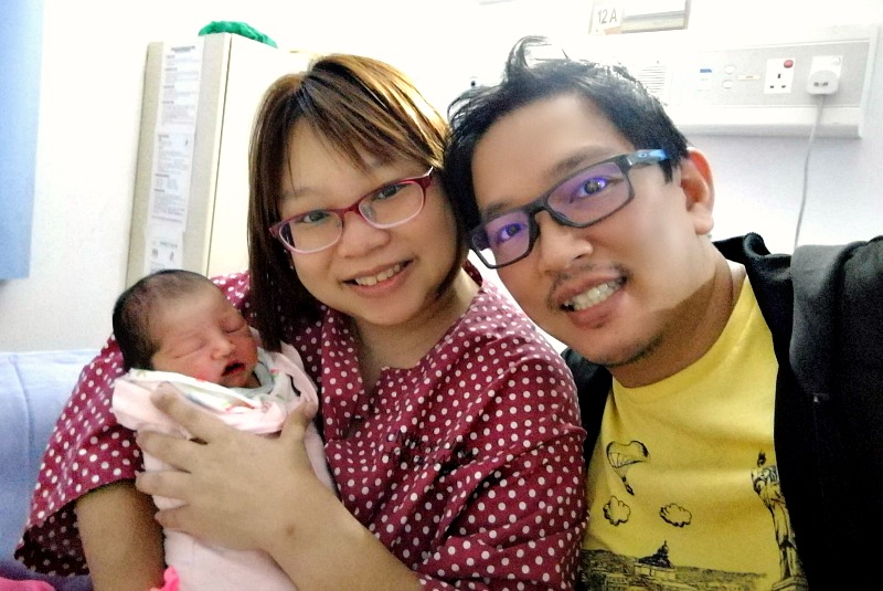 Ming and Daniel holding their newborn Avery at the hospital.