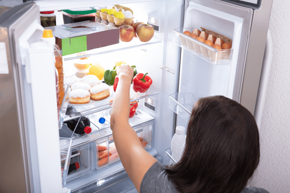 mother opening the fridge to prepare home-cooked meals