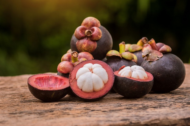 Mangosteens on a wooden surface