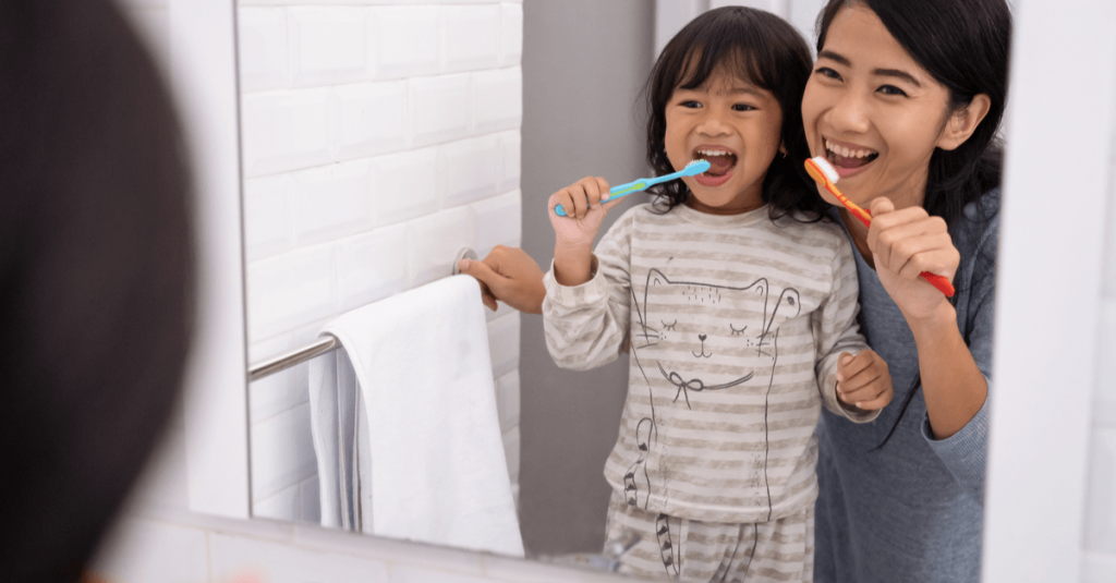 mother and daughter brushing teeth 
