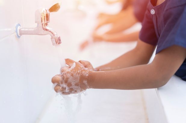 kids practise washing hands before going back to school 
