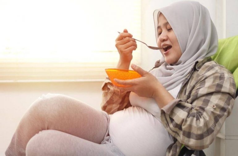 pregnant woman eating salad