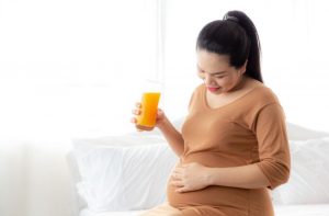 older pregnant woman drink juice