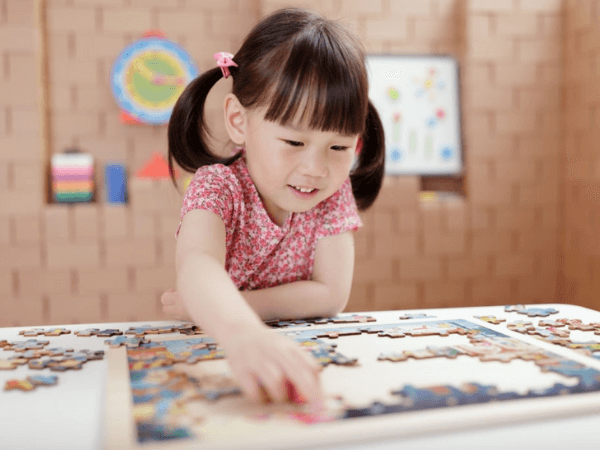 girl playing puzzle which is beneficial for her growth 