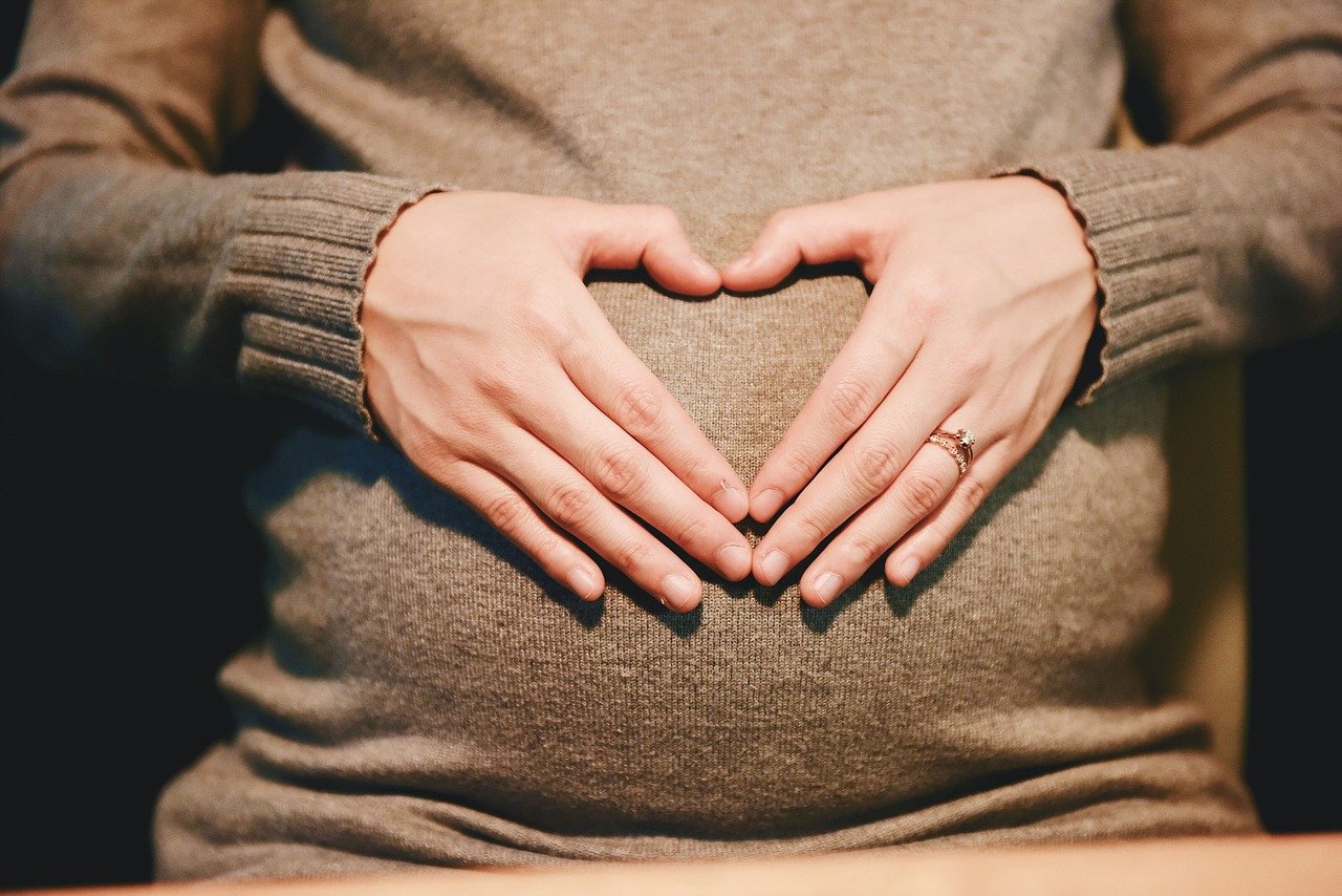 pregnant mother doing love sign 