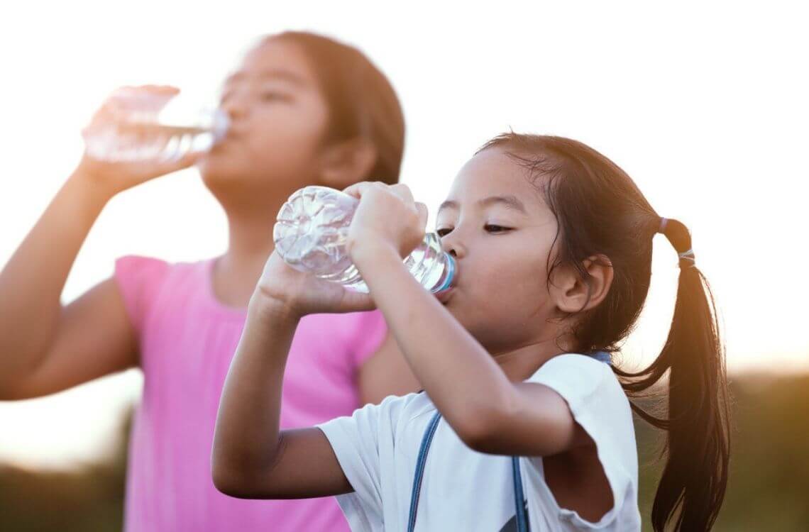 kids drink water while playing under the sun 