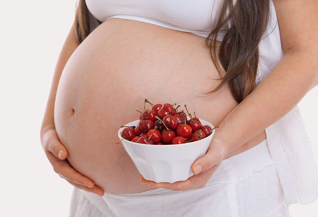 pregnant woman holding cherries