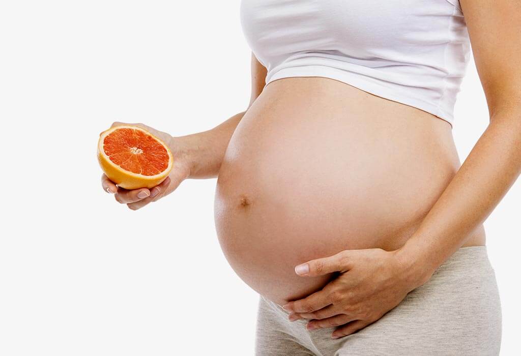 pregnant mother holding fruit