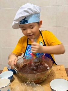 little boy is making chocolate pancake