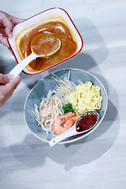 Place all the components in a bowl, then pour the laksa soup on top and serve with belacan paste and lime on the side.