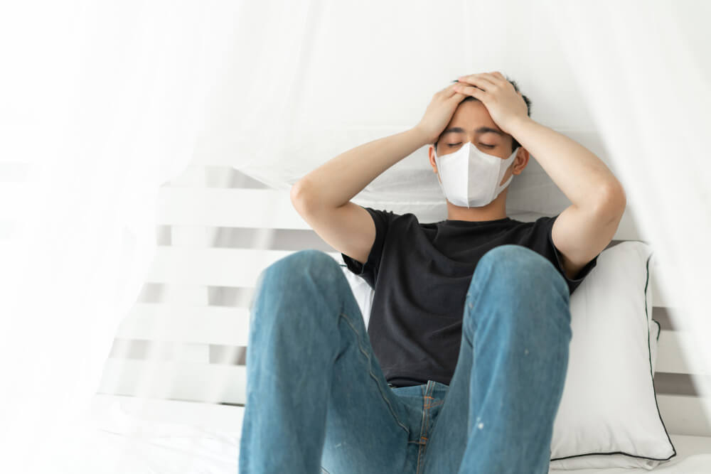 An man is feeling unwell while wearing a mask.