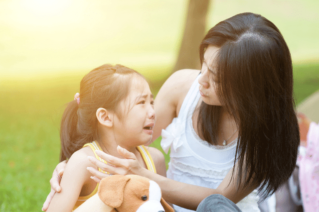 A mother is comforting her daughter who is crying calmly.