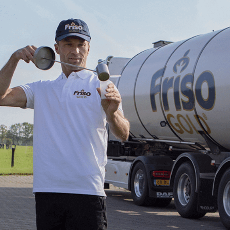 A Friso Gold milk truck driver is drawing a milk sample.