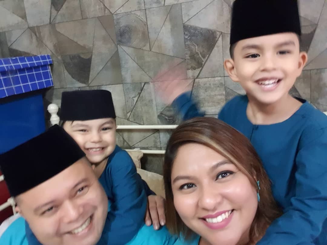 A Malay family is smiling widely for a family photo after a long conceiving journey.