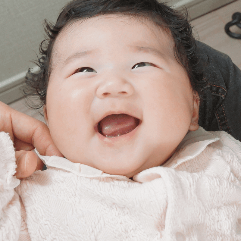 A two-month-old baby is smiling happily as mentioned in the two-month developmental milestones.