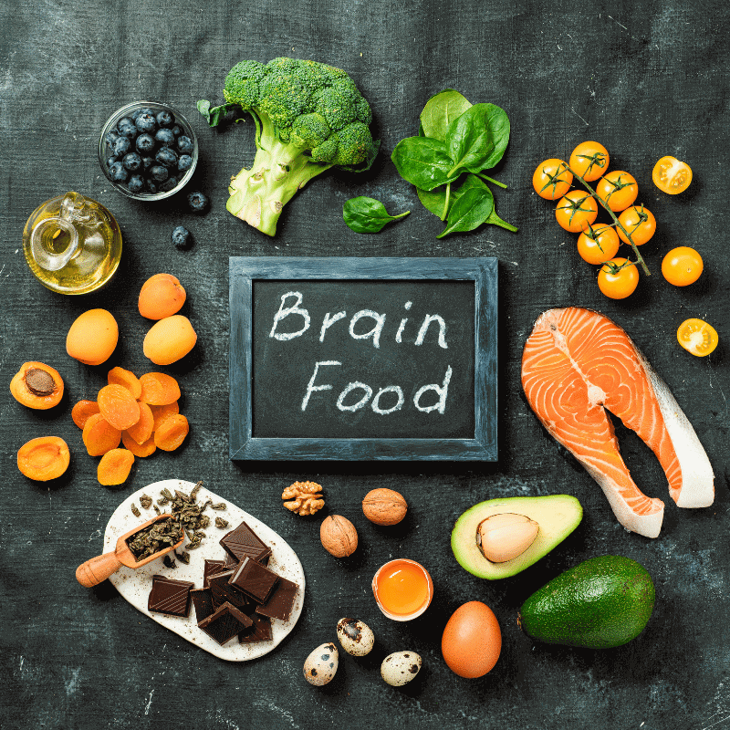 A chalkboard written 'brain food' is set with other food ingredients.