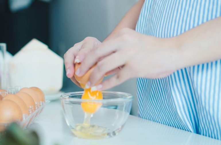 women cracking eggs