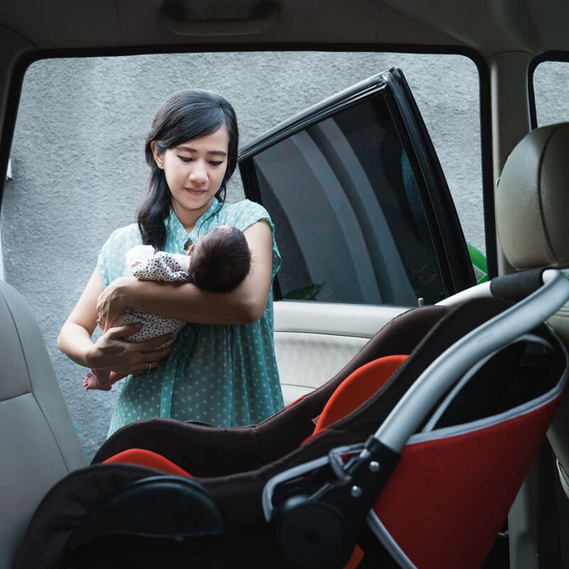 mom putting baby in child seat