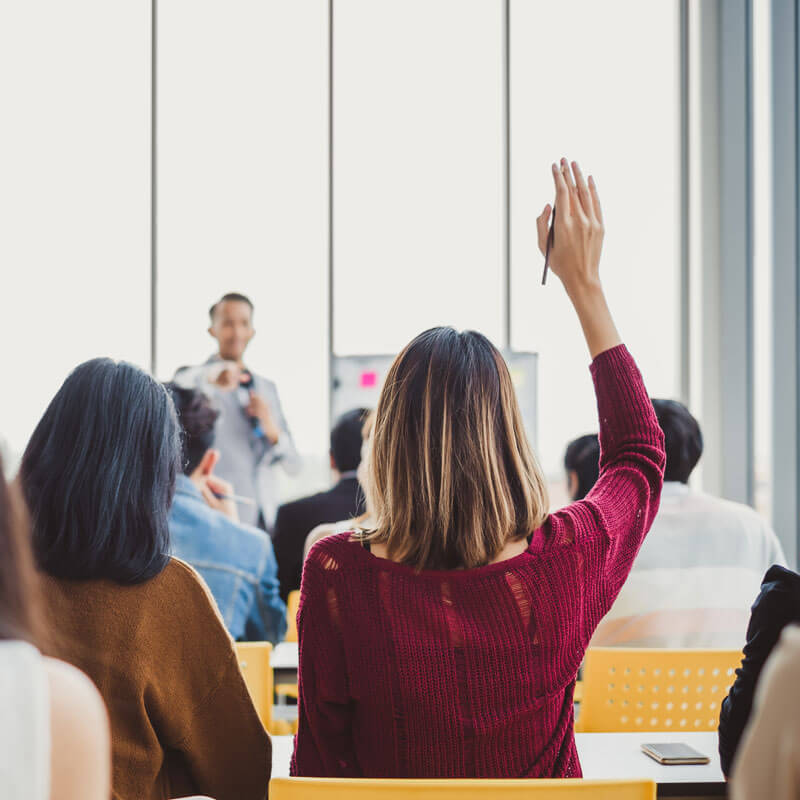 woman asking question in class