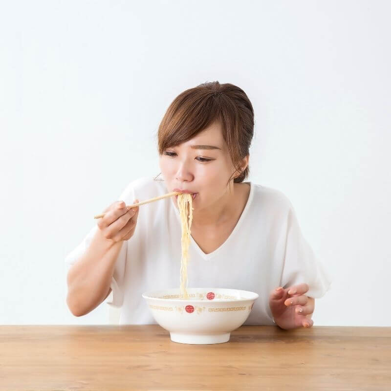woman eating instant noodles