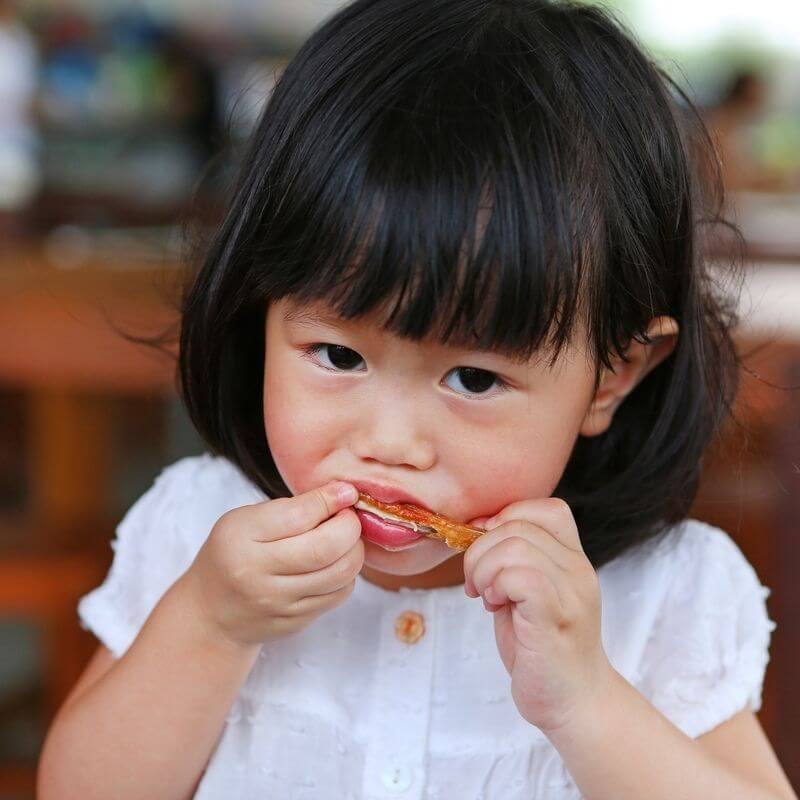 child eating chicken