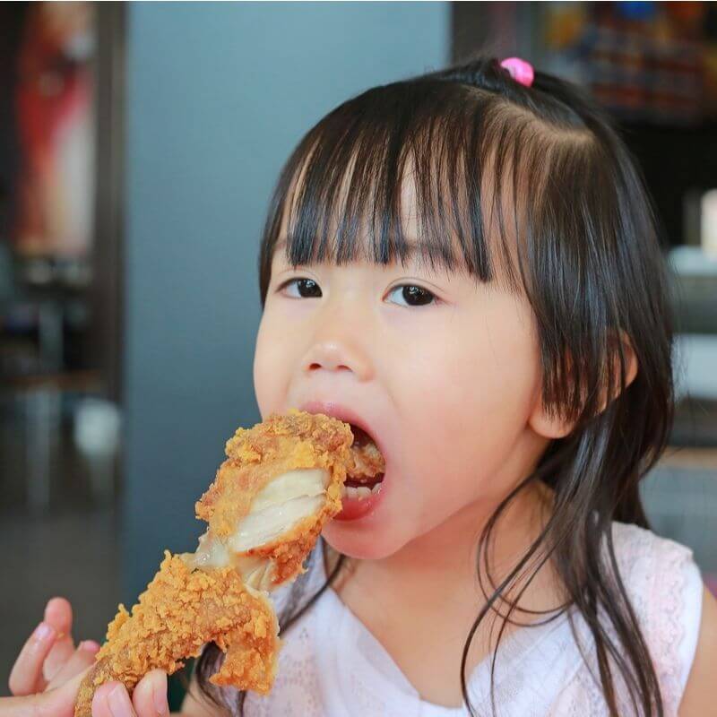 child eating chicken
