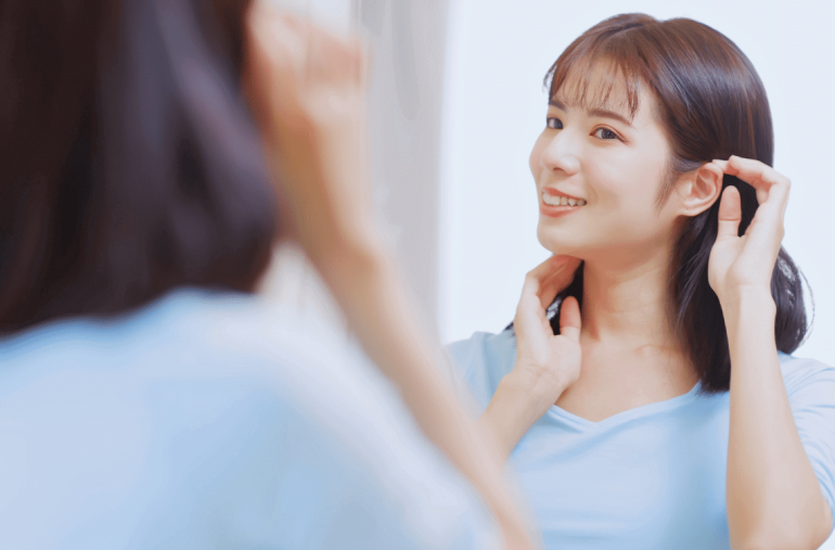 The woman is looking confidently to the mirror.