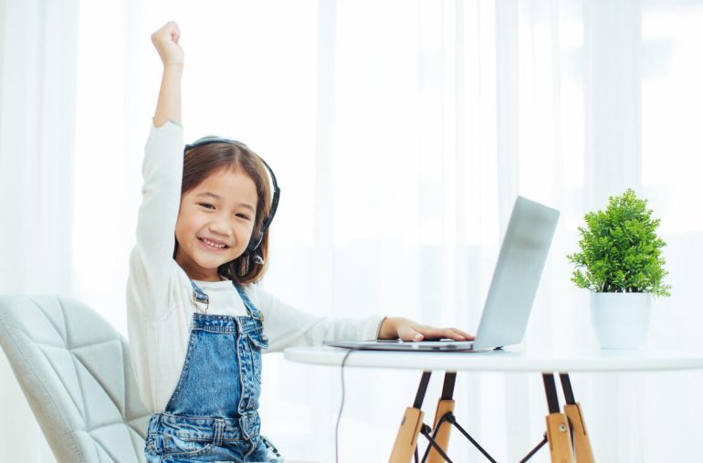 a girl happily learning online at home