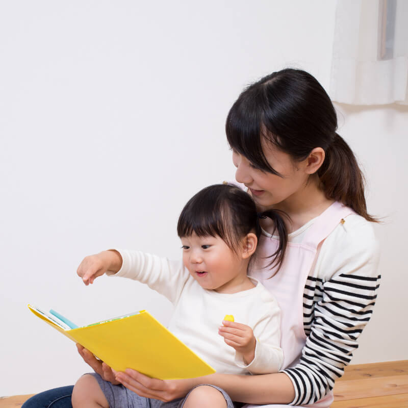Child reading aloud with mother