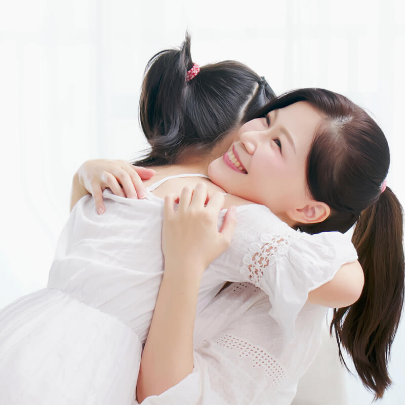 A kid is hugging her mum
