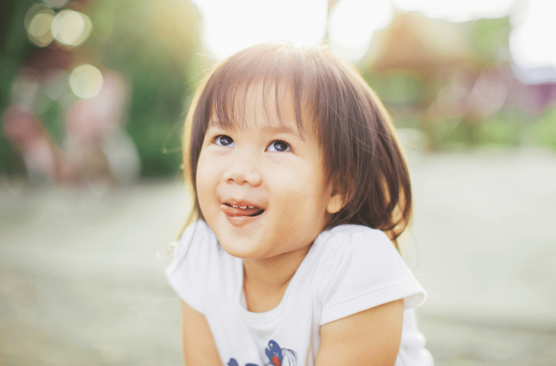 An Asian little girl is smiling cheerfully.