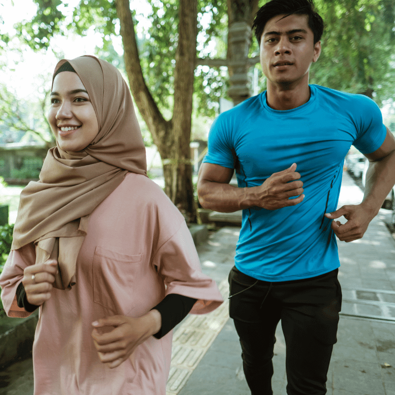 A pair of Muslim couple is jogging in the park.