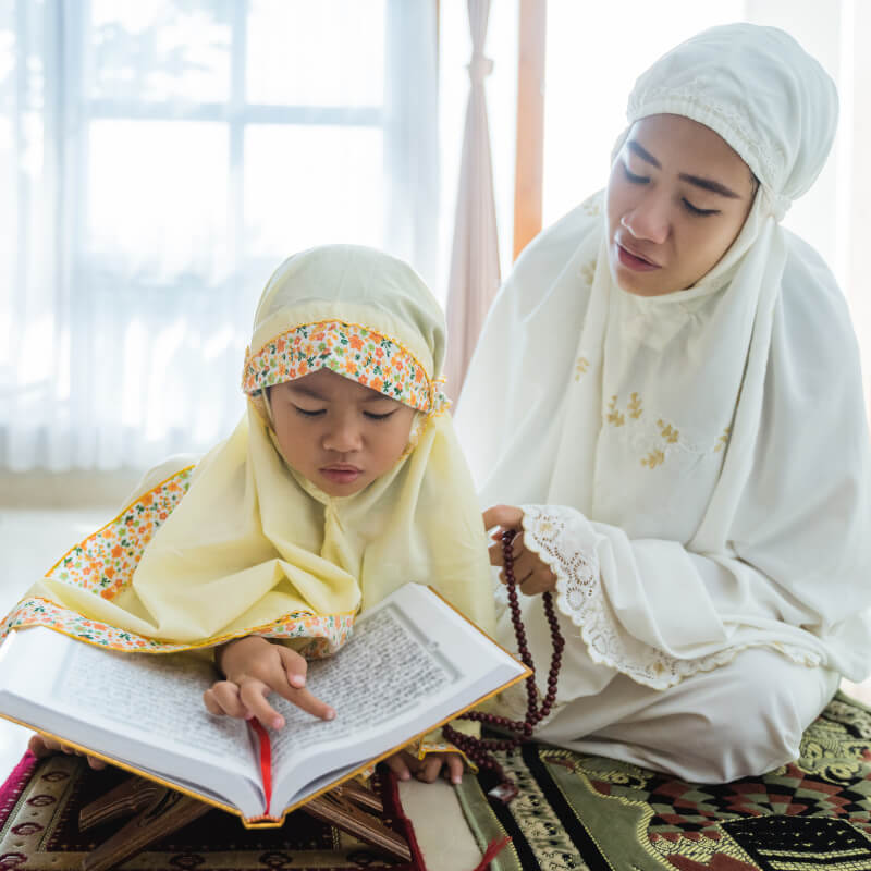 A mum reading Quran with her daughter
