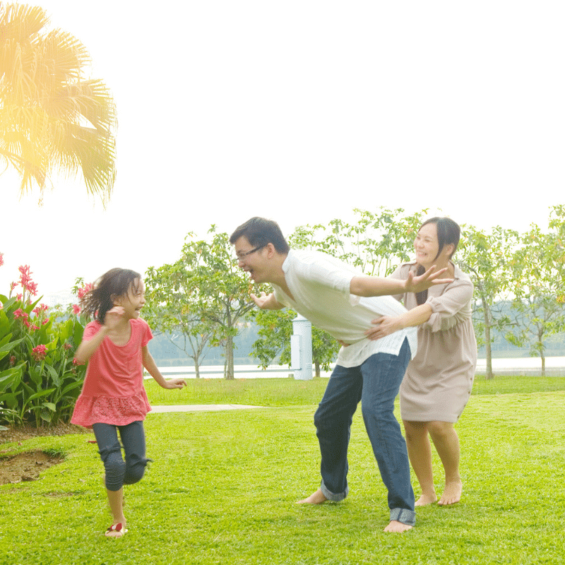 An Asian Family is playing outdoor at the park.