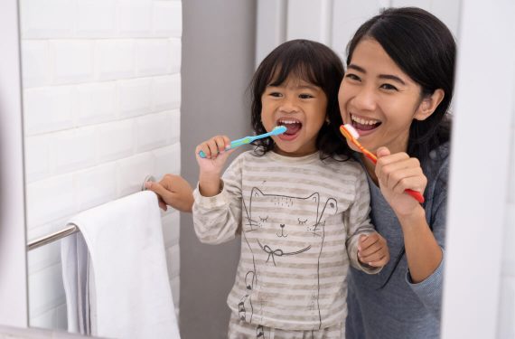 A mum and her kid brushing teeth for personal hygiene