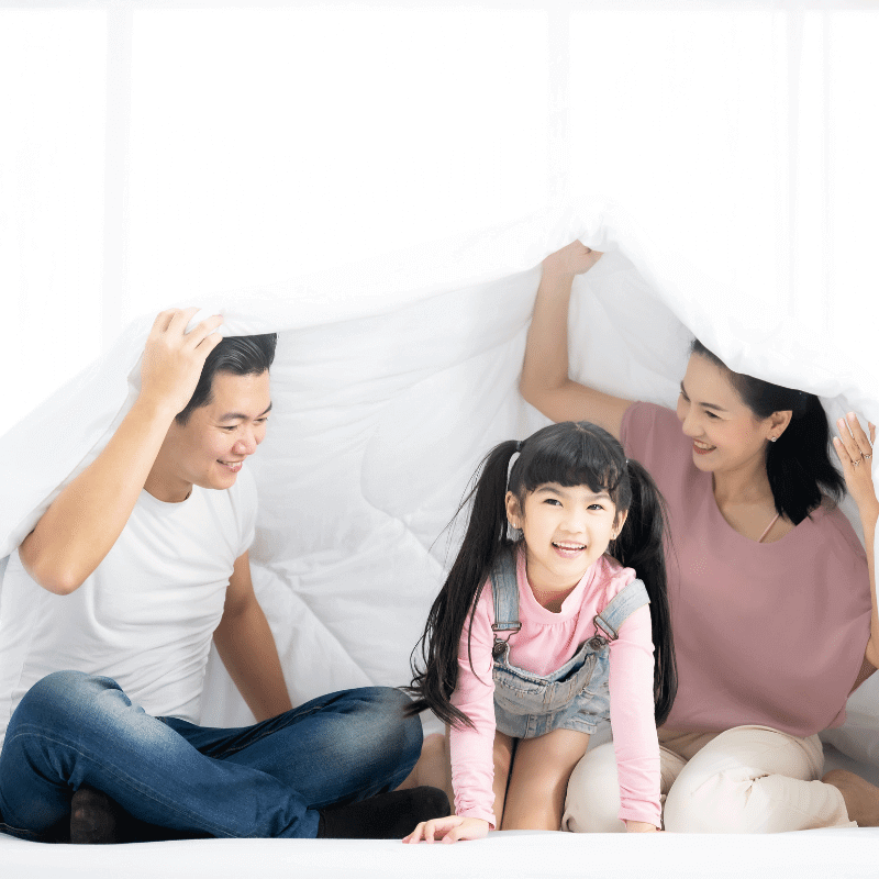 An Asian family is playing happily under the blanket.