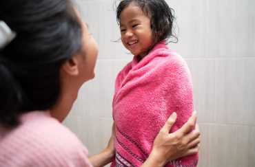 A mom teaching her daughter body care